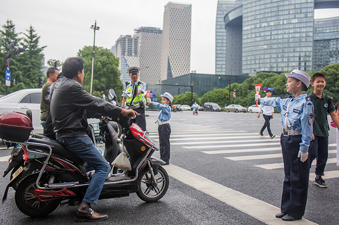 杭州少年交警中队小交警与大交警一起上路执勤，倡导文明出行。x.jpg